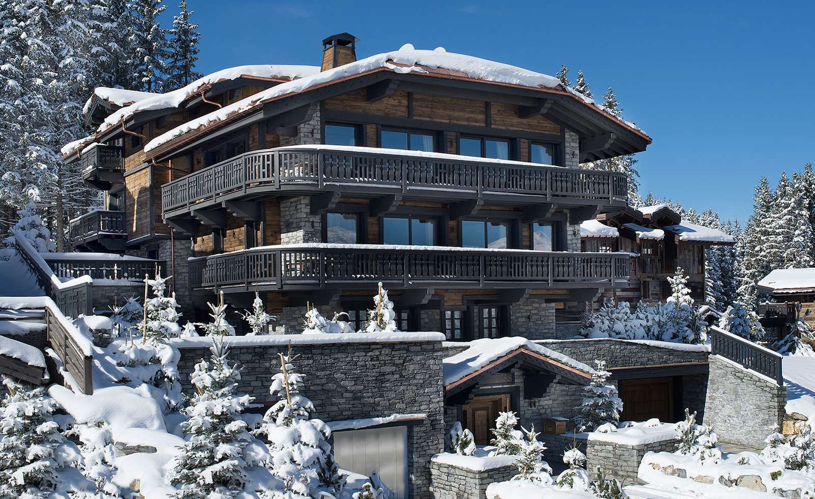 kings-avenue-luxury-chalet-courchevel-001-front-view-exterior-snow-with-blue-sky