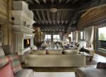 kings-avenue-luxury-chalet-courchevel-001-living-room-with-open-fireplace-side-view