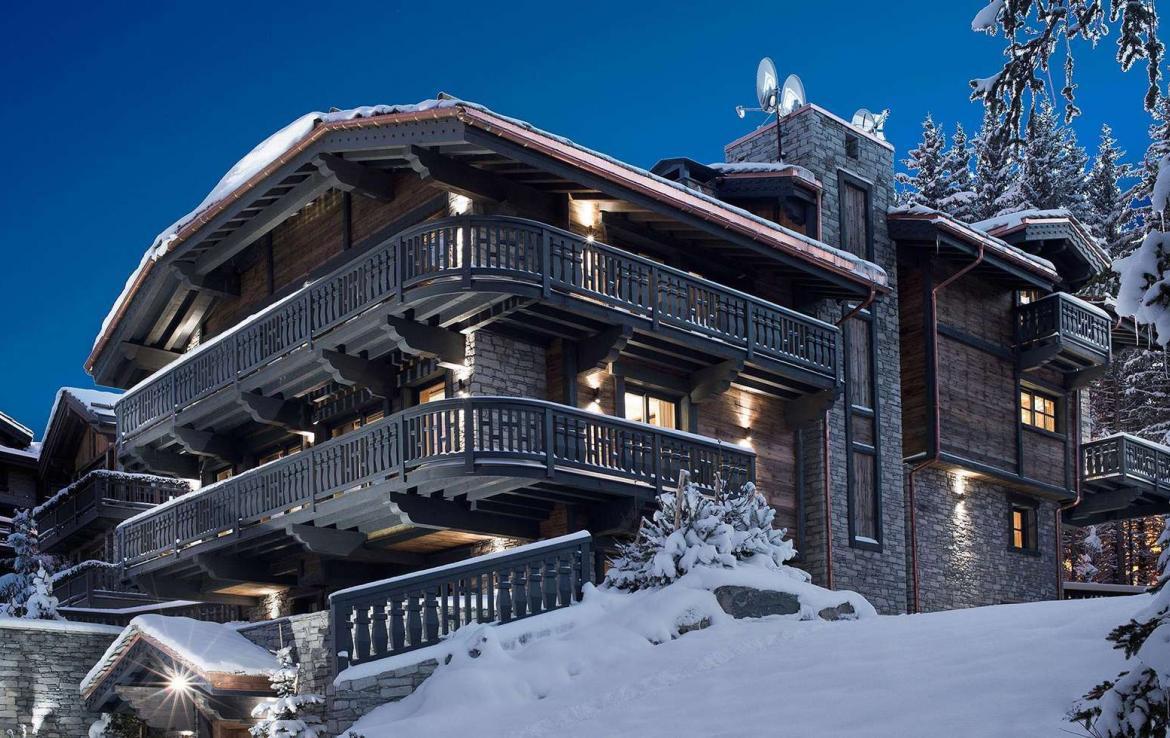 kings-avenue-luxury-chalet-courchevel-001-side-view-exterior-snow-with-blue-sky