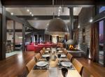 kings-avenue-luxury-chalet-courchevel-003-living-area-with-dining-table-and-open-fireplace