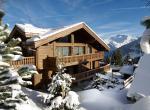 kings-avenue-luxury-chalet-courchevel-004-front-view-exterior-with-snow-and-blue-sky
