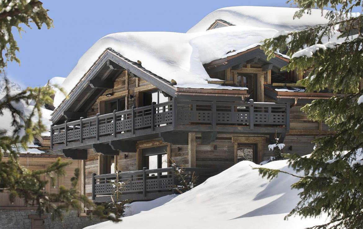 kings-avenue-luxury-chalet-courchevel-009-side-view-exterior-blue-sky-snow