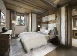 kings-avenue-luxury-chalet-courchevel-010-bedroom-with-bathroom-and-tv