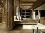 kings-avenue-luxury-chalet-courchevel-010-wooden-master-bedroom-with-tv-and-balcony